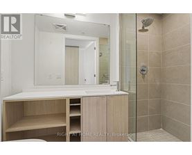 A bathroom with a sink, mirror, and shower.