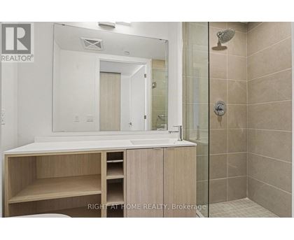 A bathroom with a sink, mirror, and shower.