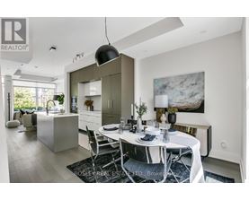 A modern dining room with a white table set for two.