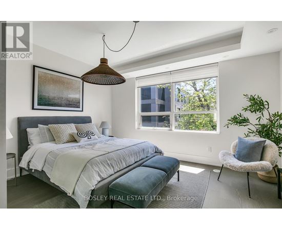 A bedroom with a large bed and a hanging lamp.