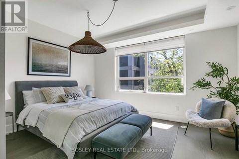 A bedroom with a large bed and a hanging lamp.