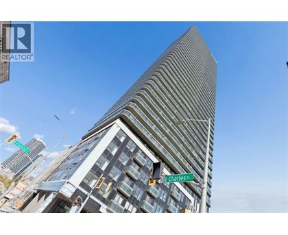 A tall building with a striped facade stands in front of a blue sky.