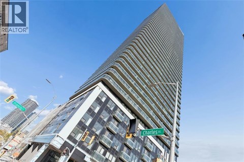 A tall building with a striped facade stands in front of a blue sky.