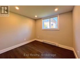 A room with a window and wooden flooring is available for exp realty.