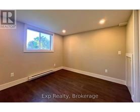 A room with a window and a wooden floor.