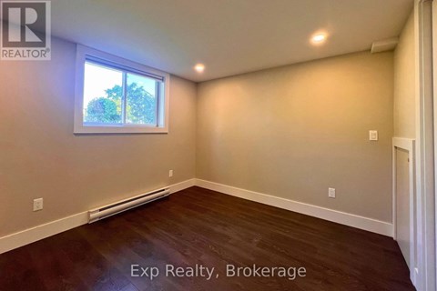 A room with a window and a wooden floor.