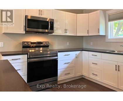 A kitchen with white cabinets and a black stove top oven.
