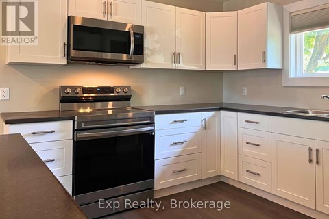 A kitchen with white cabinets and a black stove top oven.