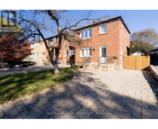 A red brick house with a tree in front of it.