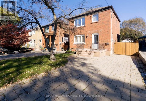 A red brick house with a tree in front of it.