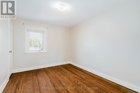 A room with a window and wooden flooring.