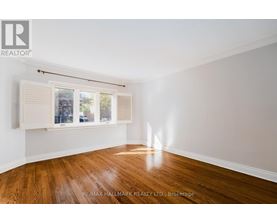 A room with wooden floors and a window with blinds.