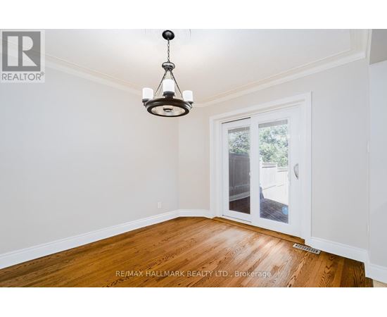 A room with a wooden floor and a chandelier hanging from the ceiling.