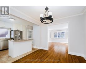 A well-lit kitchen with white cabinets and a wooden floor.