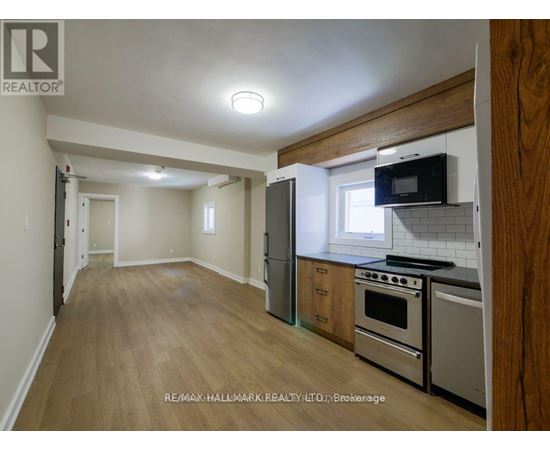 A kitchen with a refrigerator, oven, and microwave.