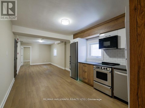 A kitchen with a refrigerator, oven, and microwave.