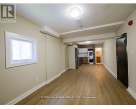 A spacious room with wooden floors and a large window.
