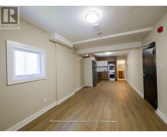 A spacious room with wooden floors and a large window.