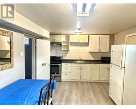 A kitchen with white cabinets and a blue tarp on the floor.