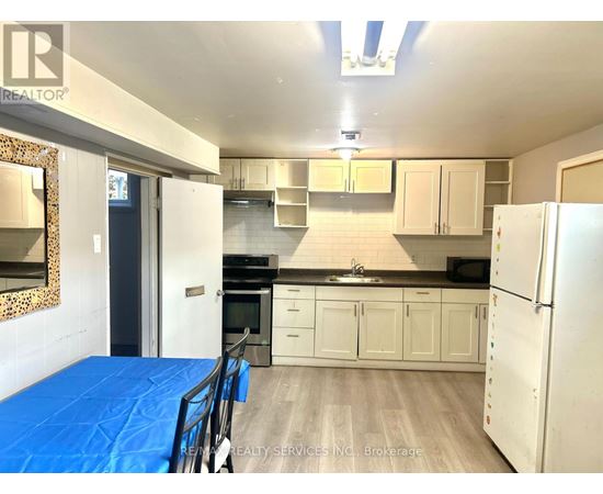 A kitchen with white cabinets and a blue tarp on the floor.