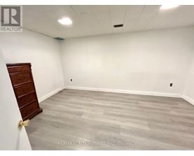 A room with a wooden door and grey flooring.