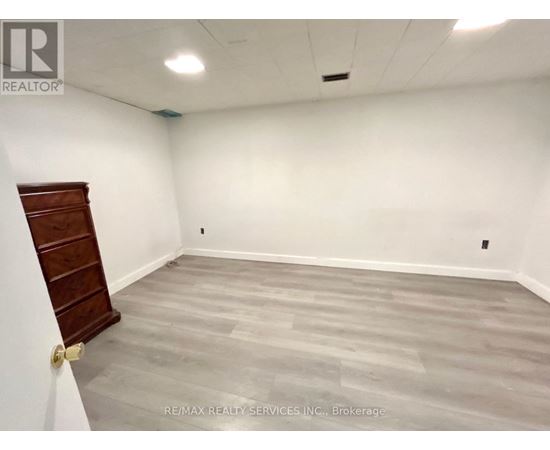 A room with a wooden door and grey flooring.
