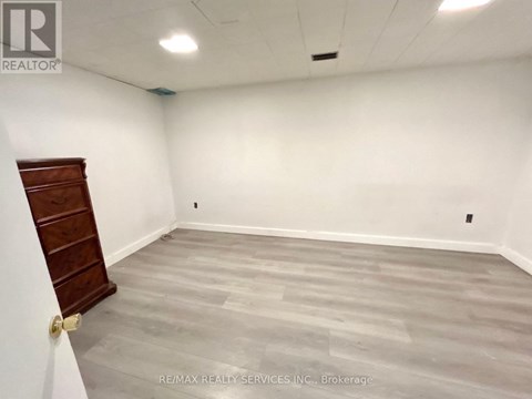 A room with a wooden door and grey flooring.