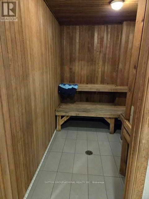 A wooden room with a bench and a hole in the floor.