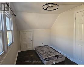 A bedroom with a bed, a window, and a ceiling fan.
