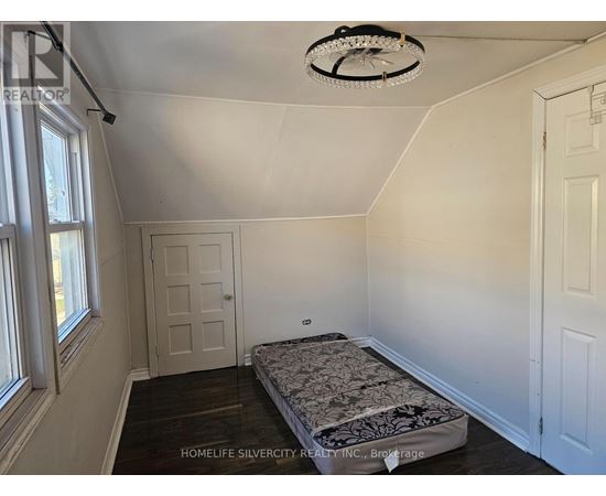 A bedroom with a bed, a window, and a ceiling fan.