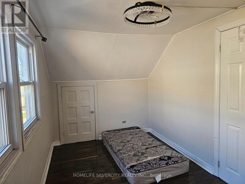 A bedroom with a bed, a window, and a ceiling fan.