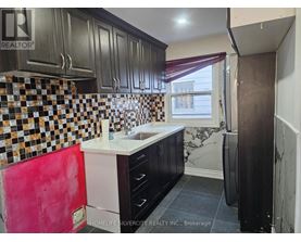 A kitchen with black cabinets and a checkered backsplash.