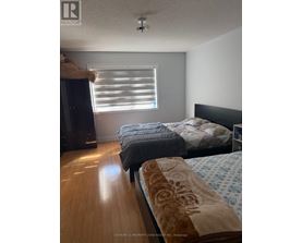 A bedroom with two beds and a dresser.