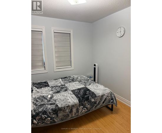 A bedroom with a bed, a clock, and a window.