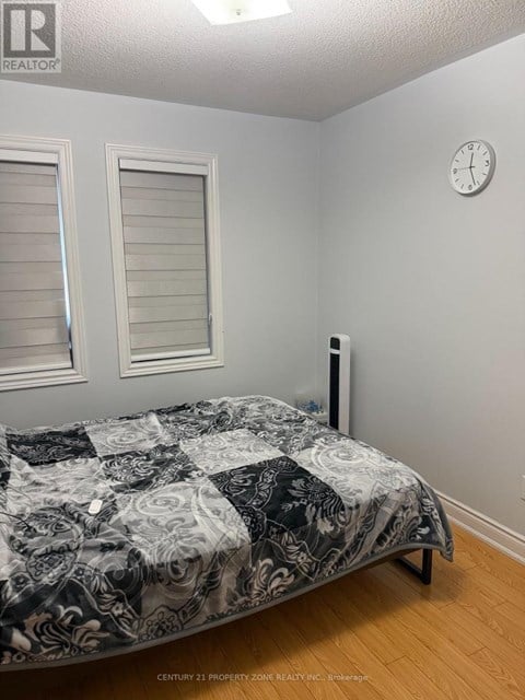 A bedroom with a bed, a clock, and a window.