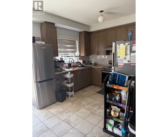 A kitchen with a refrigerator and a pantry.