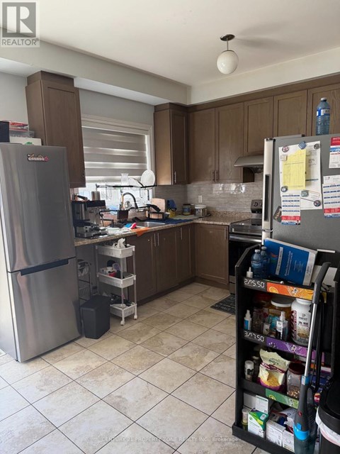 A kitchen with a refrigerator and a pantry.
