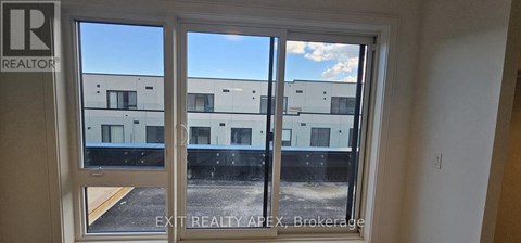A window with a view of a building and a blue sky.