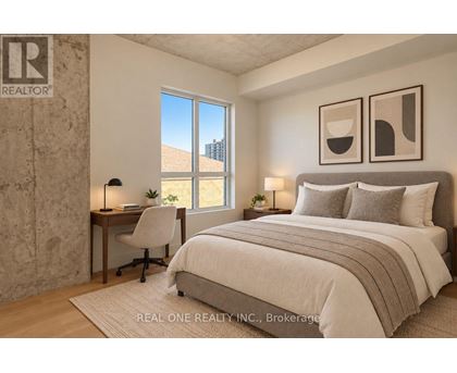 A bedroom with a large bed, a desk with a chair, and two framed pictures on the wall.