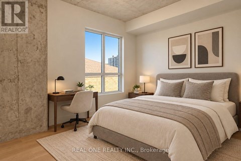 A bedroom with a large bed, a desk with a chair, and two framed pictures on the wall.