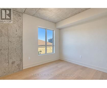 A room with a large window and a view of a building outside.