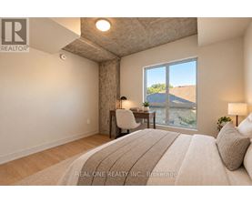A bedroom with a large bed and a view of the outdoors through a window.