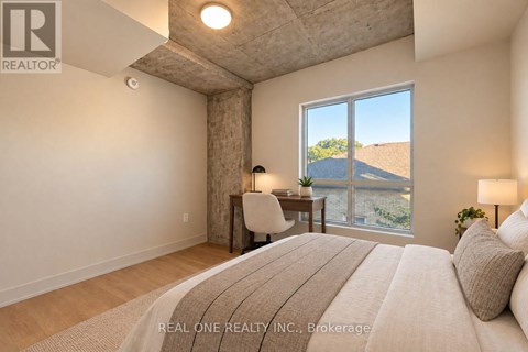 A bedroom with a large bed and a view of the outdoors through a window.