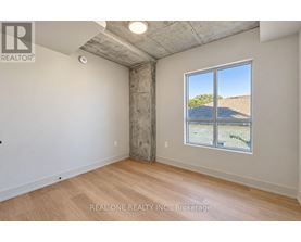 A room with a large window showing a view of a hill and a building.