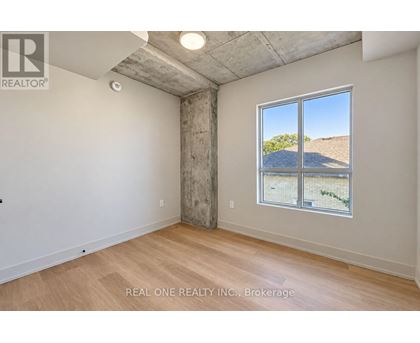 A room with a large window showing a view of a hill and a building.