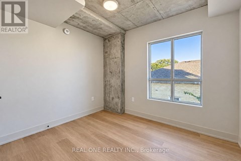 A room with a large window showing a view of a hill and a building.