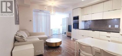 A modern kitchen with white cabinets and a dining area with a white table and chairs.