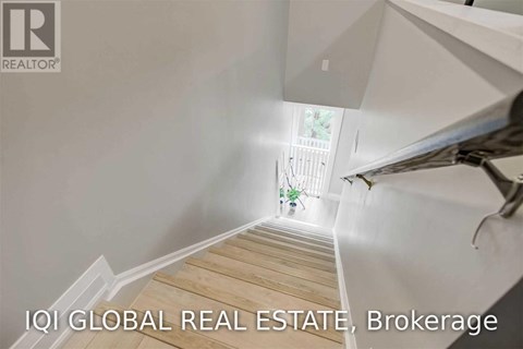 A staircase leading to a bright window in a white room.
