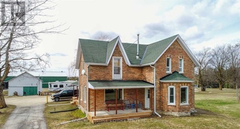 A brick house with a green roof and a sign that says "Century Realty".