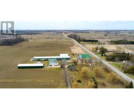 An aerial view of a farm with a sign that reads "Century 21 People 5 Choice Realty Inc. Brokerage".